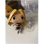 Funko Pop figure of a blonde armored female knight holding a gold weapon, standing on a clear display stand.